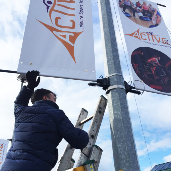 pvc lamp post banner being installed by eco print